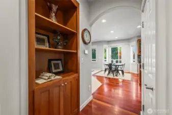 Hallway built-ins in Horizon West home for sale in North Gig Harbor showcasing custom millwork, rich cabinetry, and detailed craftsmanship leading to the kitchen and family room—highlighting the home’s quality finishes throughout.