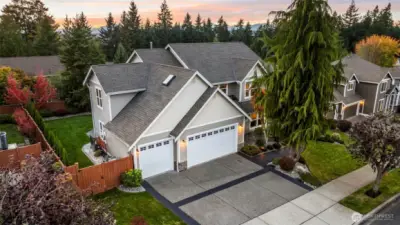 Exterior view of Horizon West home for sale in North Gig Harbor showcasing a deep 3-car garage with additional workspace, manicured landscaping, and impressive curb appeal in this gated community near Downtown Gig Harbor.
