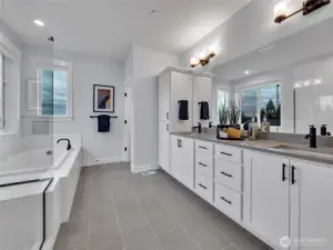 Primary bath features a dual vanity, soaking tub and shower with a bench seat highlighted by upgraded matte black fixtures/finishes found throughout the home.