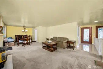 Main floor living room with gas fireplace, dining room which exits onto large wrap around deck.