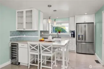 Updated kitchen with breakfast bar, wine fridge and abundant cabinets.