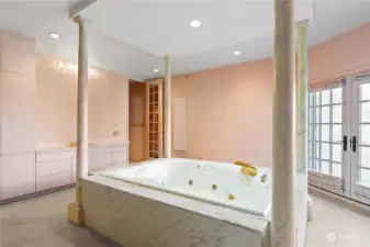 Beyond the tub is the private vanity to the left and door to the bathroom to the right