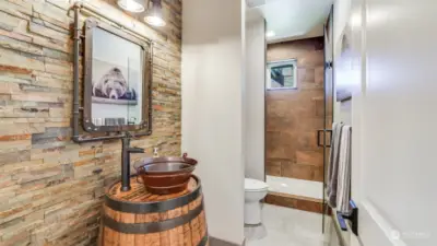 Enjoy a 3/4 guest bath with repurposed wine barrel sink!