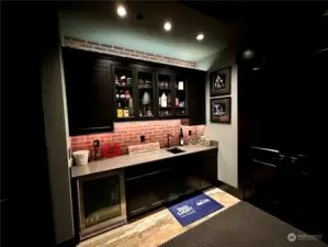 Have all your snacks and drinks ready for movie night or the big game with this wet bar complete with small fridge and plenty of storage in the theatre room.