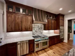 Enjoy this custom hood vent along with artisanal backsplash in tis chef's kitchen. Don't miss the double ovens, wall microwave and TWO dishwashers! Beautiful granite counter tops and leather finished granite island!