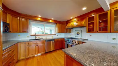 Another view of the kitchen with large window lets in plenty of natural light and an L-shaped counter large island, providing ample workspace for cooking