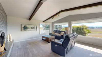 Stunning living room with a brick fireplace provide breathtaking views of rolling pastures and distant mountains