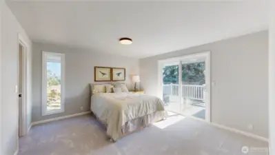 Bright and serene primary bedroom with large sliding glass door leads to a private deck