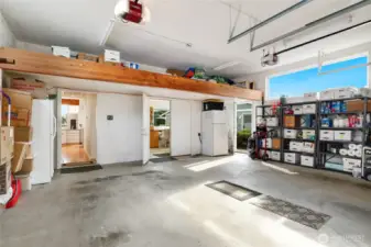 Spacious garage featuring overhead loft storage, providing plenty of room for vehicles and organized storage. Easy access into the kitchen or out the side door for a very short walk to the dock. Enter shop area from garage via the double doors. Freezer and refrigerator/freezer both stay.