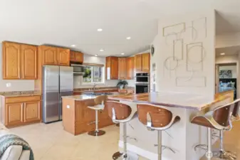 gourmet kitchen with custom raw-edge wood peninsula that seats 4 plus