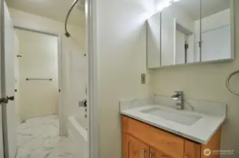 Jack and Jill design bathroom offers a private half bath in primary suite that shares a tub/shower with the hall half bath.