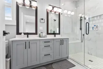 Primary bathroom with double sinks and glass shower door