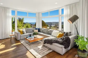 Sun drenched living room with stunning views of Elliot Bay, the sound and the Olympic Mountains.