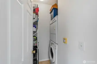 Conveniently equipped with a stacked washer and dryer, the laundry room also offers ample additional storage.