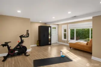 Lower level second flex space. Stairway leads up to the garage. The laundry room is to the right of the window/lounge.