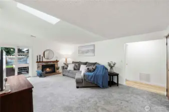Large living area with vaulted ceiling and skylight