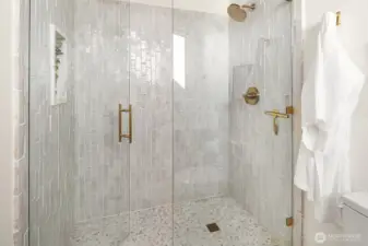 Giant shower with mountain views and marble niche.
