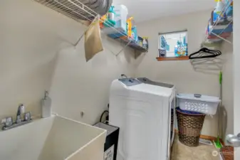 Laundry room with sink and storage racks.