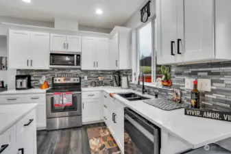 Sparkling countertops, full height backsplash, and stainless appliances make this kitchen shine.