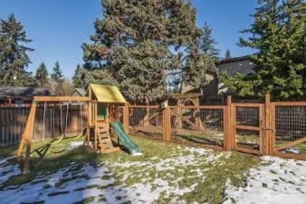 Massive, fully fenced yard with dog run, play structure, and gardening space.