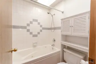 Common bathroom, stool, jetted tub and shower.