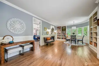 The curved bank of windows are flanked by floor to ceiling bookcases, there is beautiful wainscotting and a gas fireplace.