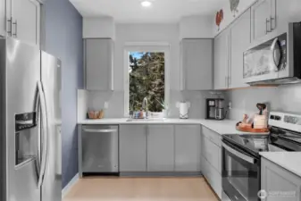 Gourmet kitchen with stainless appliances & quartz counters.