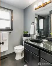 Primary bath also has granite countertops and a full granite shower.  There is also a linen closet behind the bathroom door
