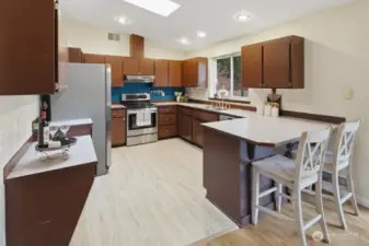 Chef-inspired kitchen boasts stainless appliances, breakfat island, and plenty of cabinetry for storage