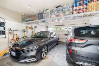 2-car garage has clever overhead built-in storage & hose hook up.