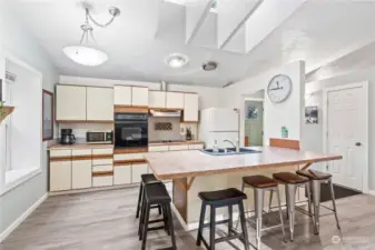 Kitchen w/Peninsula for lots of Seating!  Vaulted Ceilings, Skylights and Light Cabinetry keep the space living large!