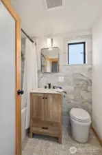 Heated floors in this marble-tiled full bathroom