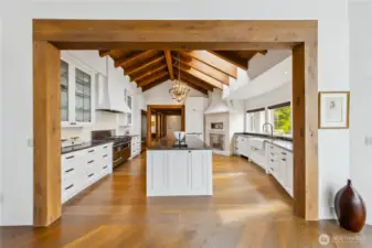 A culinary space designed with intention — vaulted ceilings, reclaimed beams, and artisan details create an atmosphere as inviting as it is functional.  Abundant counter spaced, 6 burner stove plus griddle, double oven, warming drawers, and commercial pizza over surrounded by Italian stone.