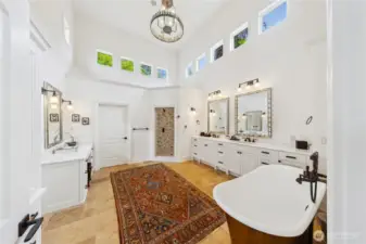 The spa-inspired bath features an English copper soaking tub, radiant floor heat (which is throughout the home), a spacious walk-in shower, and a chandelier engineered to lower for easy care.