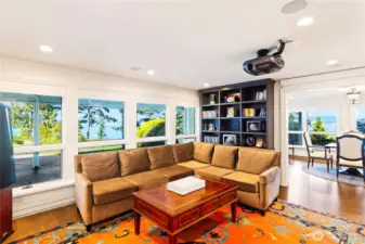 A state-of-the-art media room includes a motorized drop-down screen, projector, and wet bar for immersive cinematic experiences.