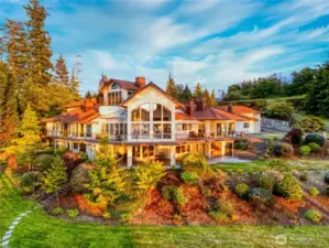 The residence is designed to embrace its setting, with expansive windows and tiered patios that connect seamlessly to the landscaped grounds.