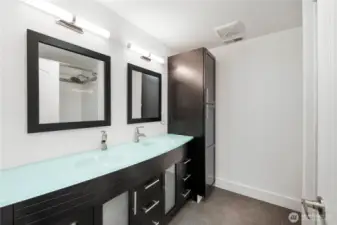 Impressive guest bathroom with dual sinks and abundant cabinetry.