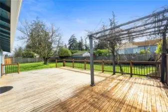 A yellow cedar deck with wrought iron railing and an arbor provides the perfect spot to enjoy summer BBQs.