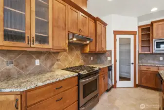 Gas cooktop, trash compactor, dishwasher, microwave and a walk-in pantry behind the door.