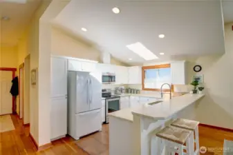 View of front entry hall showng kitchen with breakfast bar and skylight