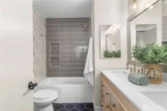 Fully updated tile in the primary bath, new vanity and light fixtures!