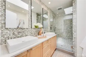 Gorgeous guest bath with tile and skylight.