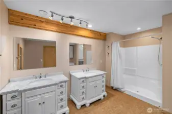 Primary bath with large shower enclosure and double vanities.