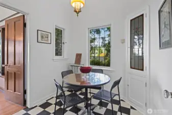 The charming breakfast nook hosts a cabinet with a stained glass door that matches the glass door from the kitchen.