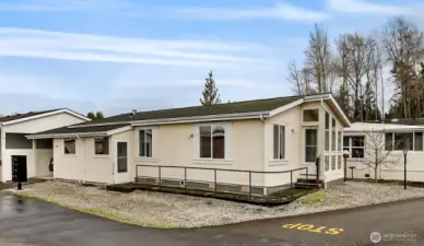 Side of the home showing the carport, Front Door area with a walkway from the Front door to the Side Door where an Outdoor Porch is located.