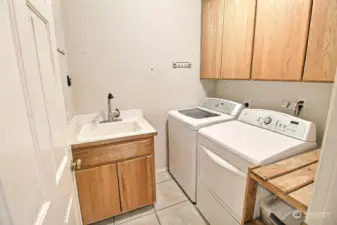 Main Level Laundry Room with built-in Cabinets and Sik.