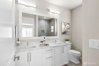 Primary bathroom with thick slab quartz counters, double undermount sinks and a large fully tiled shower.