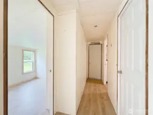 Looking down the hall and the first bedroom on the left. Primary is at the end of the hall. Notice Vaulted ceilings  in the bedroom.