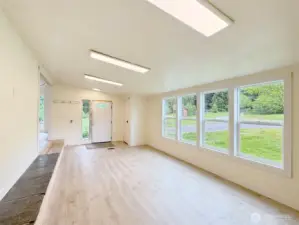 Living room with vaulted ceilings, and wall of windows for light.