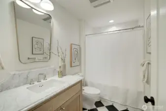 Lower level bathroom featuring AnnSacks Carrara marble tile and countertop, Fuller fixtures, Bedrosian shower tiles